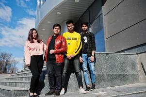 grupo de amigos asiáticos parados en las escaleras al aire libre contra un edificio moderno. foto