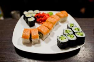 Different sushi rolls with fish on the plate. photo