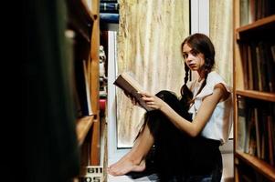 Girl with pigtails in white blouse at old library. photo