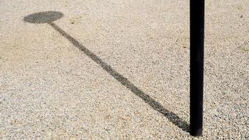 Shadows of black pillars falling on the gravel floor. photo