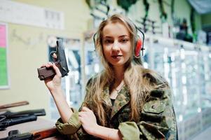 Disparando al campo de tiro. La mujer en el campo de tiro disparó con una pistola. foto