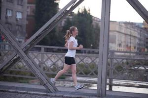 mujer deportiva corriendo en la acera foto