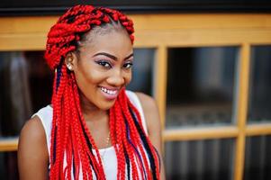 Fashionable african american girl at pink pants and red dreads posed outdoor. photo