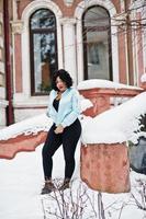 Stylish african american plus size model at streets of city on winter day. photo