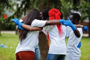 Group of happy african volunteers hugs in park. Africa volunteering, charity, people and ecology concept. photo