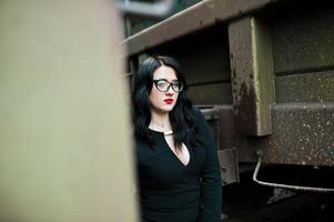 Brunette girl wear in black with glasses in railway station. photo