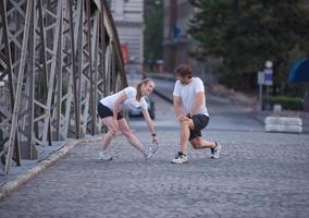 couple warming up and stretching before jogging photo