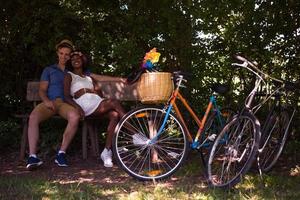 joven pareja multiétnica dando un paseo en bicicleta en la naturaleza foto