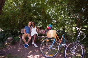 joven pareja multiétnica dando un paseo en bicicleta en la naturaleza foto