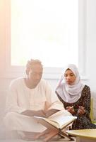 african couple at home reading quran photo