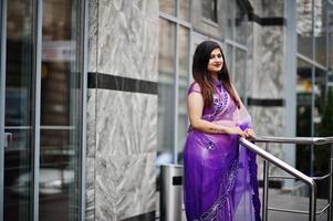 Indian hindu girl at traditional violet saree posed at street. photo