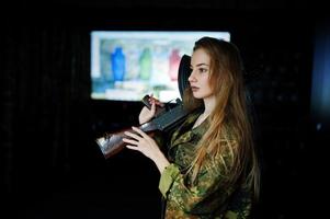 Girl with machine gun at hands on shooting range. photo