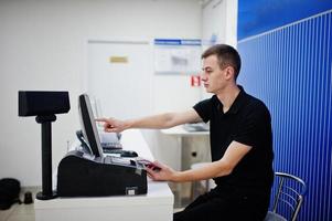 vendedor hombre consultor profesional de telefonía móvil en tienda de tecnología o tienda trabaja en el cajero. foto