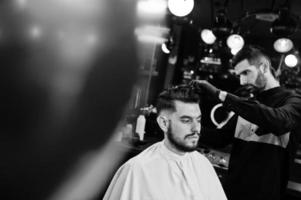 Handsome bearded man at the barbershop, barber at work. photo