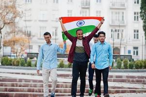 grupo de cuatro hombres indios del sur de asia con bandera india. foto