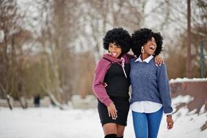 Two curly hair african american woman wear on sweaters posed at winter day. photo