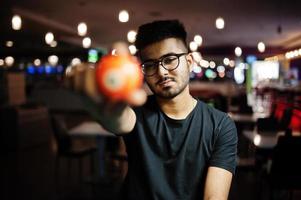 un hombre asiático elegante sostiene una bola de billar. foto