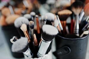 Many brushes on a table in the salon. Workplace makeup artist. Set of brushes for makeup. photo
