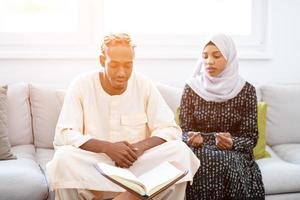 african couple at home reading quran photo