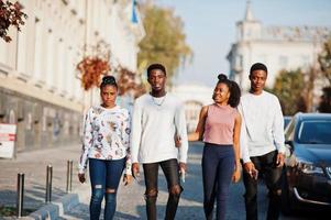 Four african friends walking the streets of an ancient city. photo