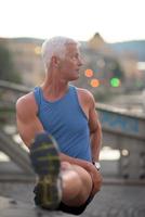 handsome man stretching before jogging photo