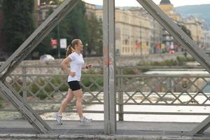 sporty woman running  on sidewalk photo
