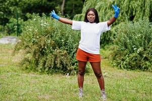 mujer voluntaria africana en el parque. Concepto de voluntariado, caridad, personas y ecología de África. foto