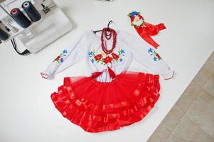 Children's carnival hand made girl costume at seamstress office on workplace. photo