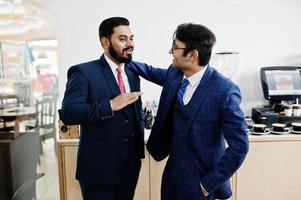 Two indian businessman in suits standing on cafe and discuss each other. photo