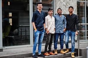 Group of four indian mans, wear on casual clothes, posed outdoor at street of India. photo