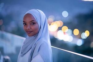 African  modern Muslim woman in night at balcony photo