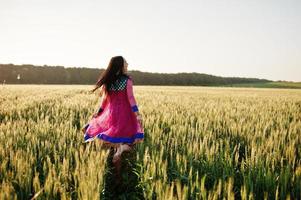 Tender indian girl in saree, with violet lips make up posed at field in sunset. Fashionable india model. photo