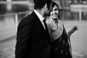 Elegant and fashionable indian friends couple of woman in saree and man in suit walking together and holding hands. photo