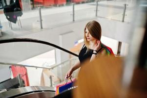 Girl with shopping bags in the mall at the escalator. photo