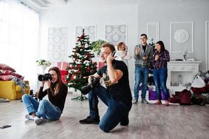 The team of two photographers shooting on studio behind another three workers. Professional photographer on work. photo