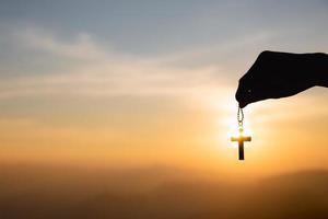 Religious concept, human hand holding a Christian cross necklace. jesus christ cross easter resurrection concept photo