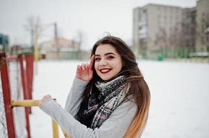 Brunette casual girl in scarf at winter on street. photo