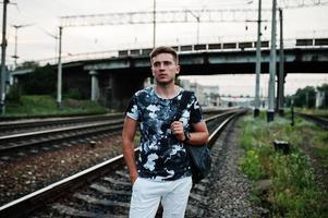 retrato de estilo de vida de un hombre guapo posando en la estación de tren. foto