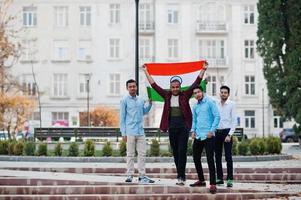 grupo de cuatro hombres indios del sur de asia con bandera india. foto