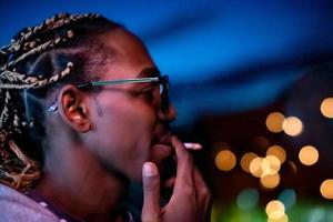 hombre afroamericano fumando cigarrillo por la noche foto