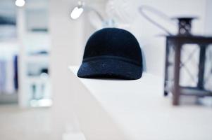 Close-up photo of a black cap on the shelf in the shop.