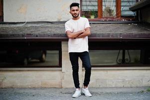 hombre de barba india con estilo en camiseta rosa. modelo india posó al aire libre en las calles de la ciudad. foto