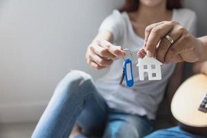 Couple holding new house key in their hands and buying a new home and are moving together.business and real estate concept photo