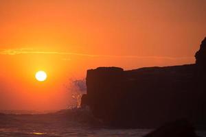 sunset over hindu temple Pura Tanah Lot, Bali, Indonesia photo