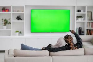 African Couple Sitting On Sofa Watching TV Together photo