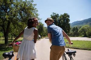 Young multiethnic couple having a bike ride in nature photo