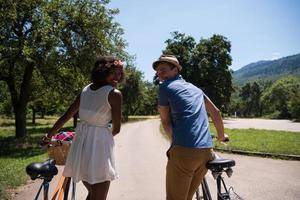 Young multiethnic couple having a bike ride in nature photo