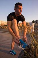 man tying running shoes laces photo