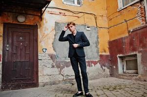 Young stylish macho boy in black jacket posed outdoor of street. Amazing model man. photo