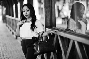 Stylish african american business woman with handbag on streets of city. photo